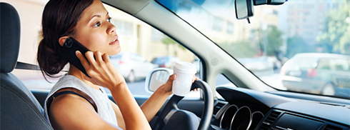 Driver on the phone and drinking coffee